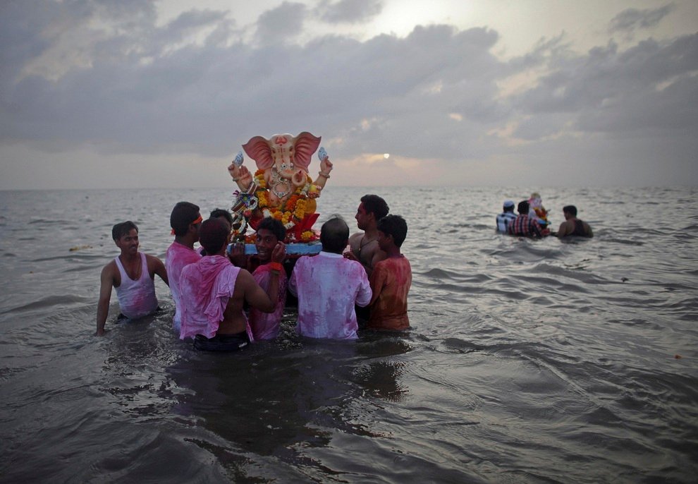 Верующие несут статую индуистского божества Ганеши в воды Аравийского моря, Мумбаи, Индия, на первый из десяти дней фестиваля «Ганеша-Чатуртхи». 