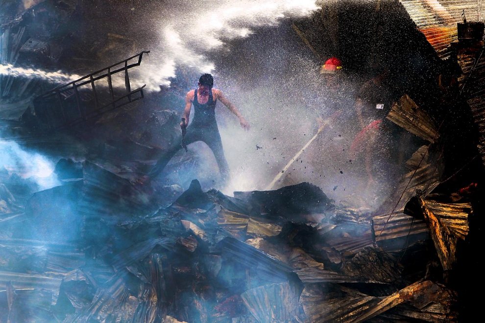 Пожарные и местные жители пытаются взять под контроль огонь в трущобах Дакки, Бангладеш. Возгорание привело к уничтожению не менее 500 лачуг.