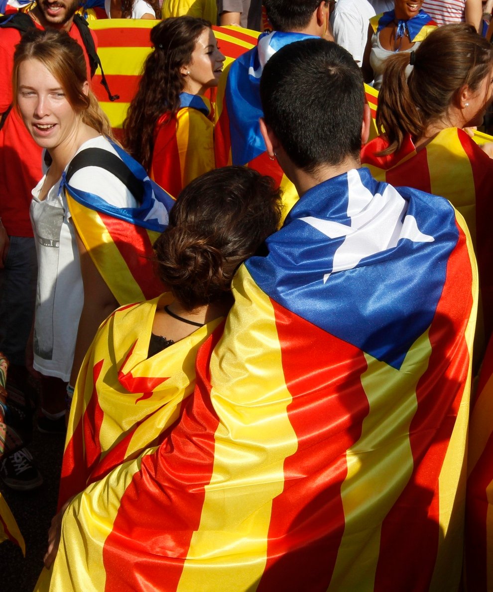 A couple wrapped in a Catalonian nationalist flag take part in a demonstration during Catalan National Day in Barcelona