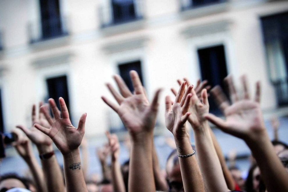Демонстранты Бро поднимают руки вверх во время митинга в Мадриде, Испания. Испанцы протестуют против финансового кризиса в стране, который, по их мнению, возник из-за недобросовестных банков и коррумпированных политиков.